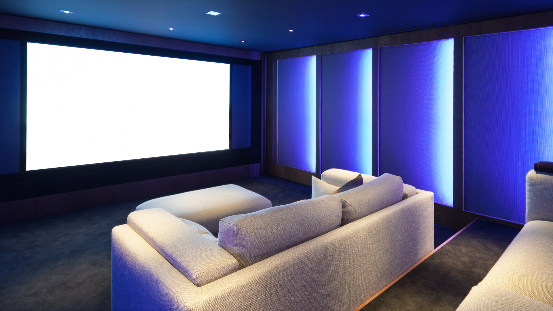 A home theater with a couch and a large screen