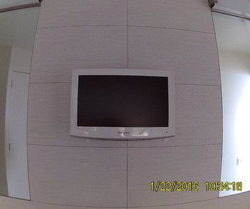 A white flat screen tv is hanging on a wall.