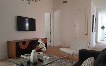 A living room with a couch , chair , coffee table and television.