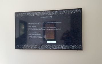 A flat screen tv is hanging on a white wall.