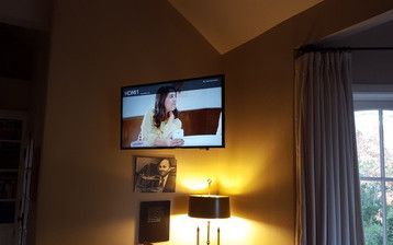 A flat screen tv is hanging on a wall in a living room.