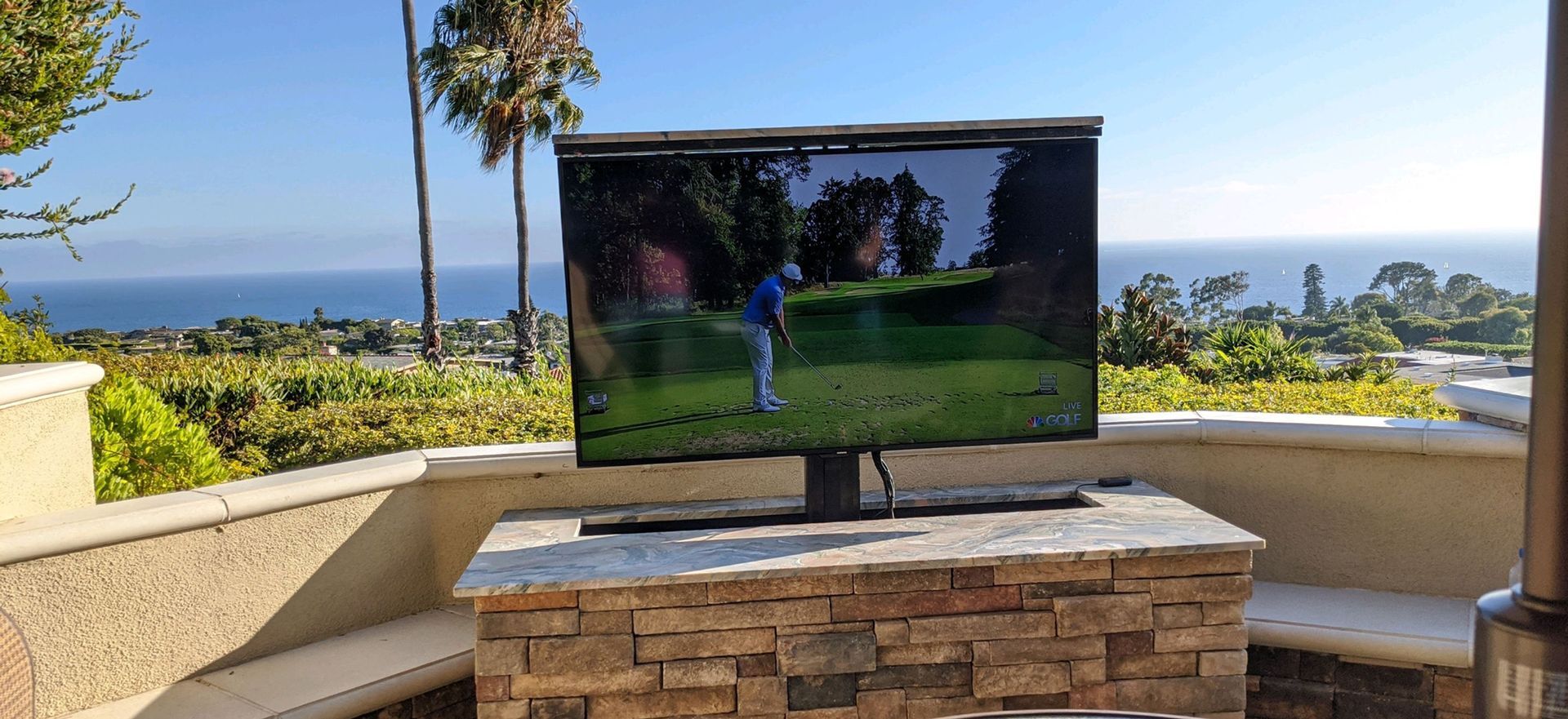 A flat screen tv is sitting on top of a stone table.