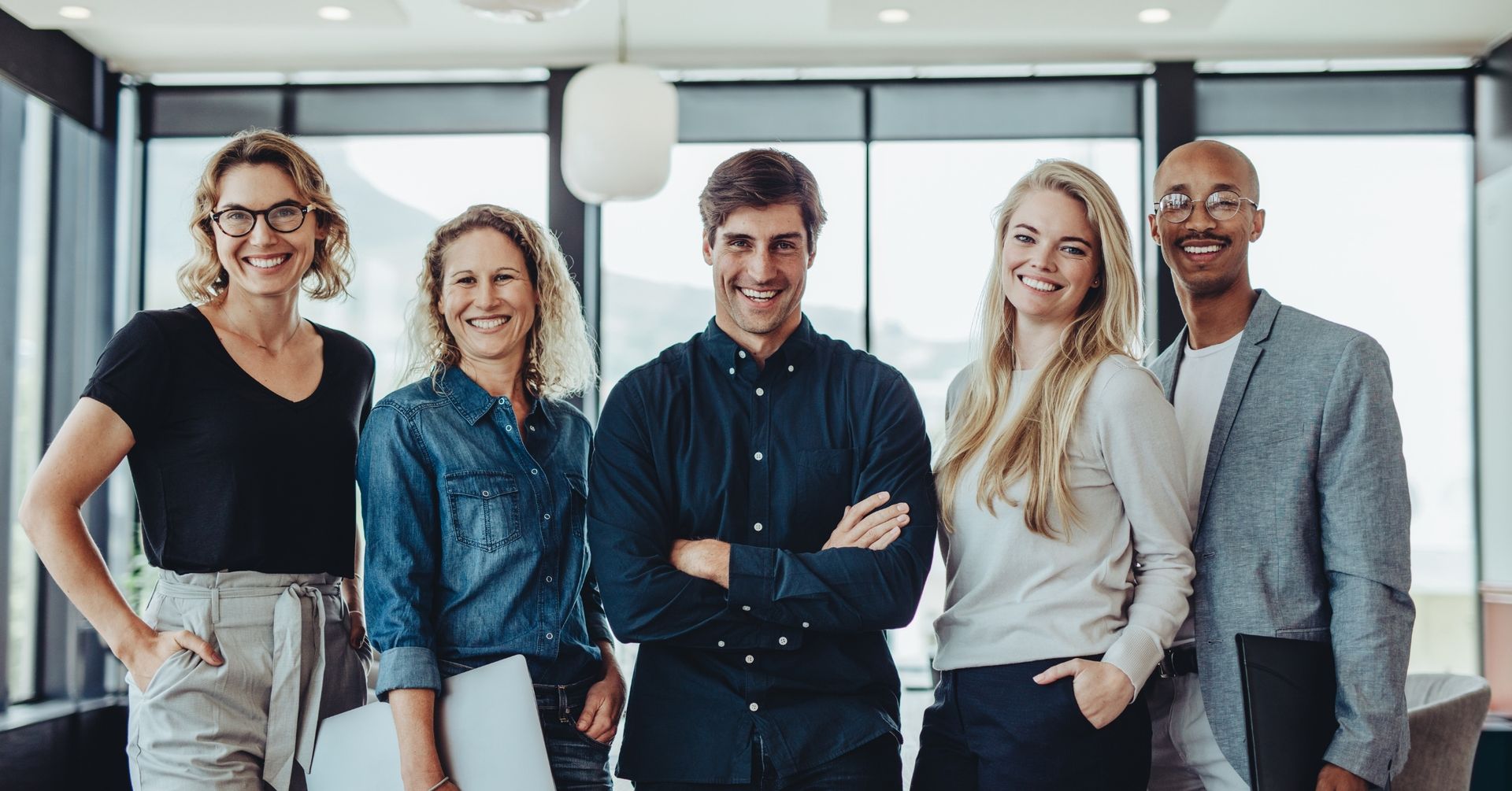 confident and aligned small business team standing together in a modern office