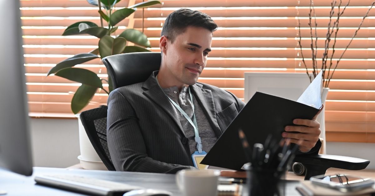 Calm business owner reviewing documents at his desk, representing the shift from reactive firefighti