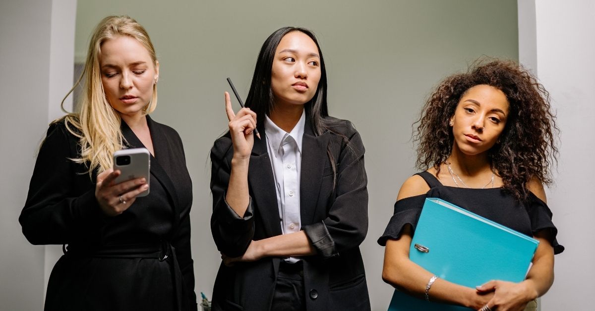 Disengaged business team members standing apart, representing the breakdown in team communication an