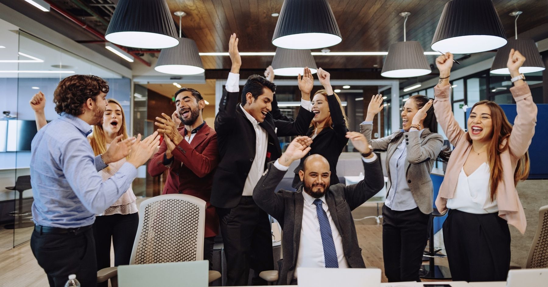 Energised business team celebrating a shared win in a modern office