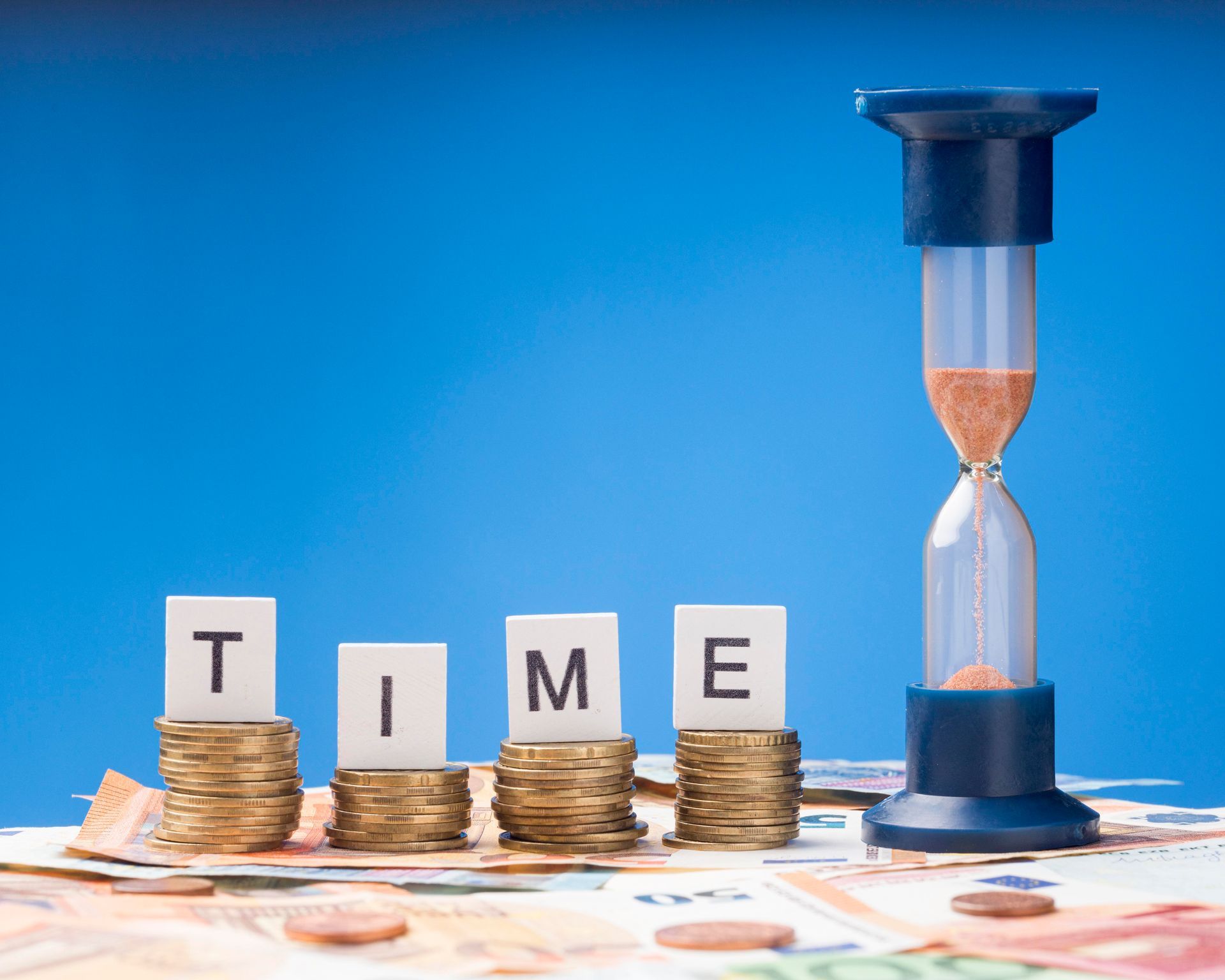 Hourglass beside a pile of coins representing how Australian business owners should strategically