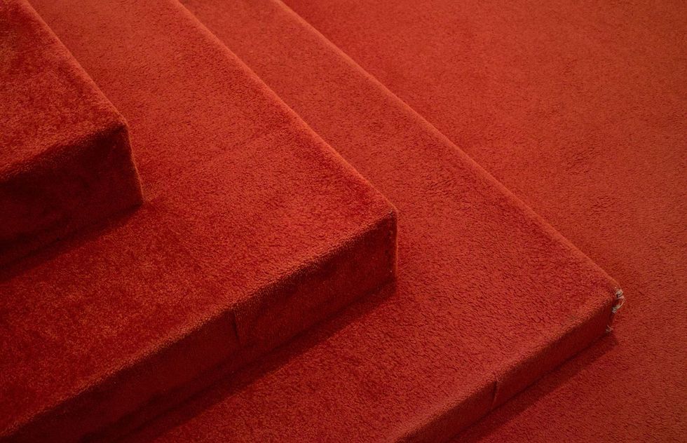 Red-carpeted stairs viewed at an angle in close-up.