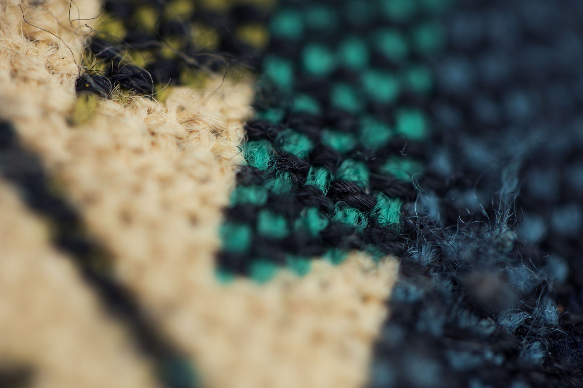 Close-up of a woven fabric with beige and teal threads