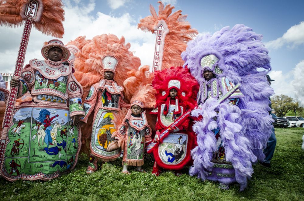 A group of people dressed in colorful costumes are standing in a field.
