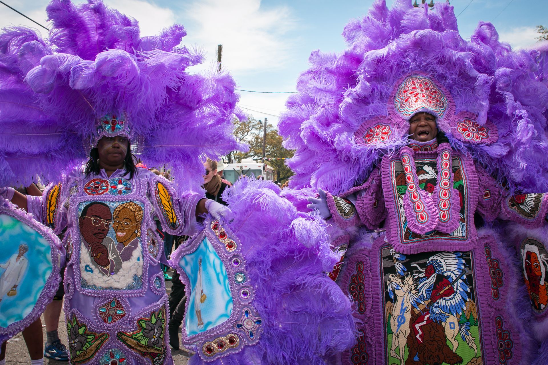Two people in purple costumes are standing next to each other in a parade.