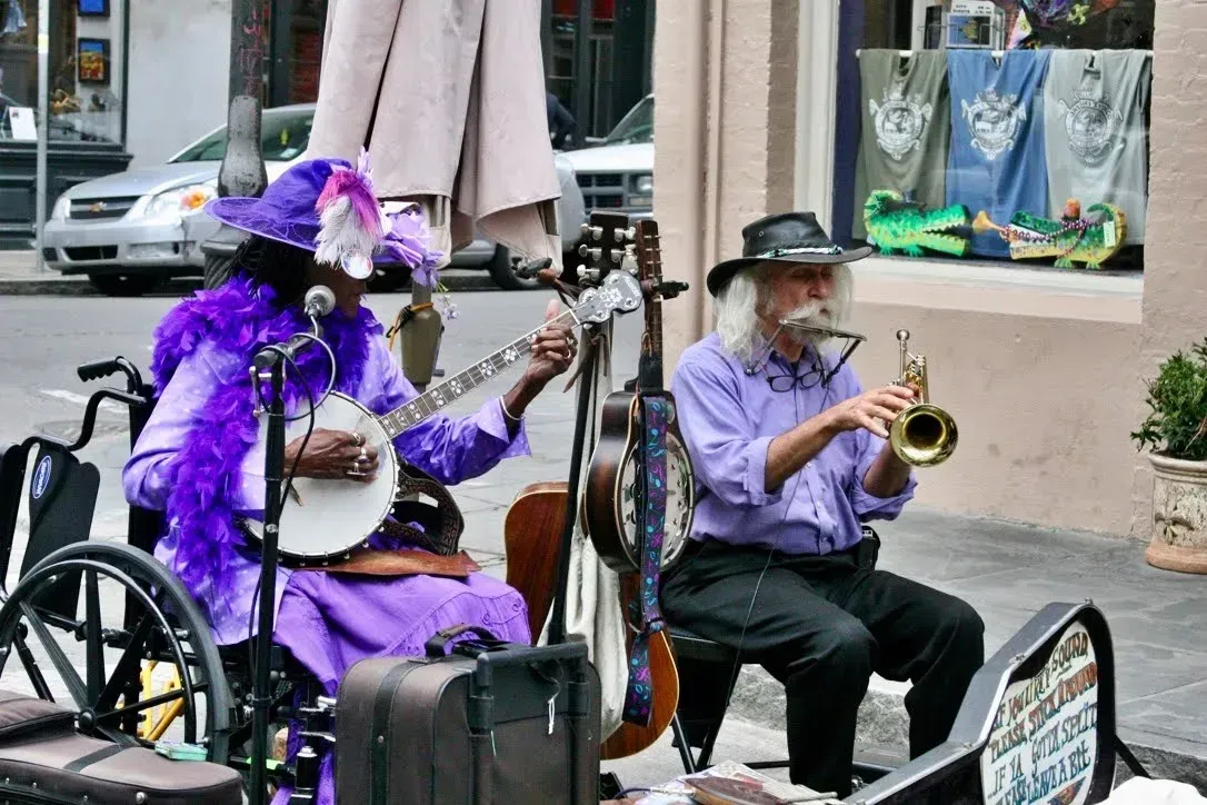 A woman in a wheelchair is playing a banjo and a man is playing a trumpet.