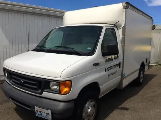 White box truck with company logo parked outside, sunny day.