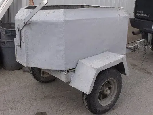Gray metal box trailer with two wheels, attached to a vehicle.