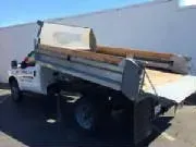 White dump truck with raised bed, parked outside.