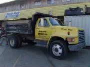 Yellow dump truck parked in front of a building.