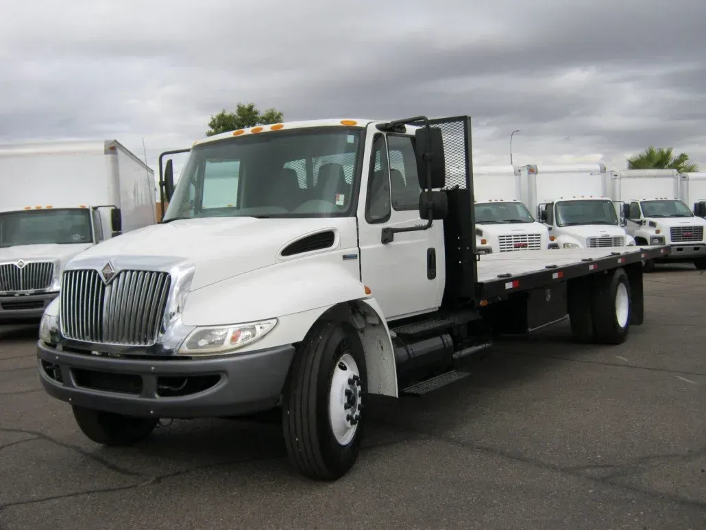 White International flatbed truck in a parking lot.