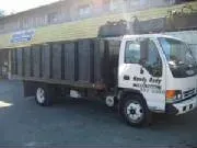 White dump truck parked outside a building, with