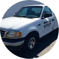 White Ford F-150 pickup truck with company logo on the side.