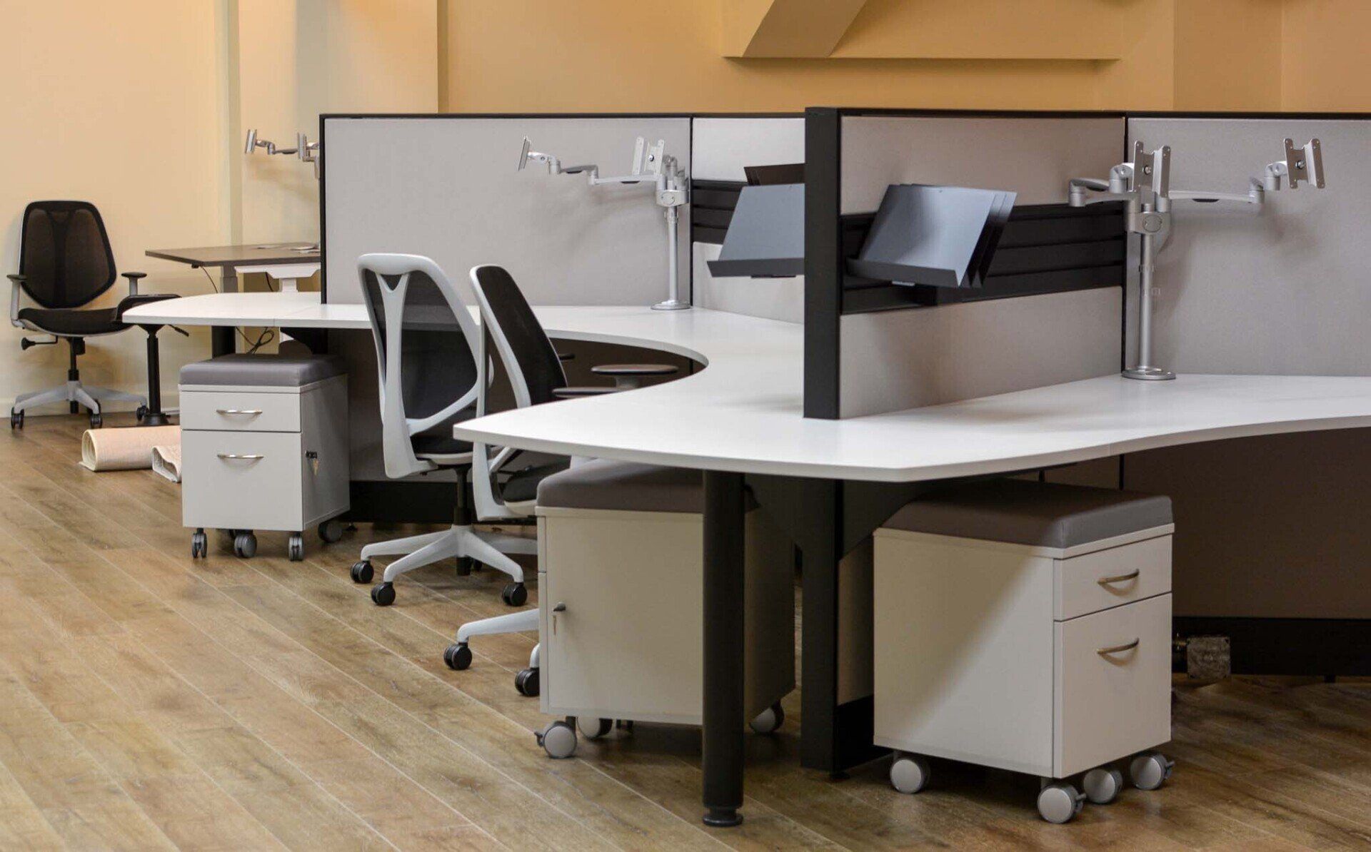 a cubicle with a white desk and a black chair