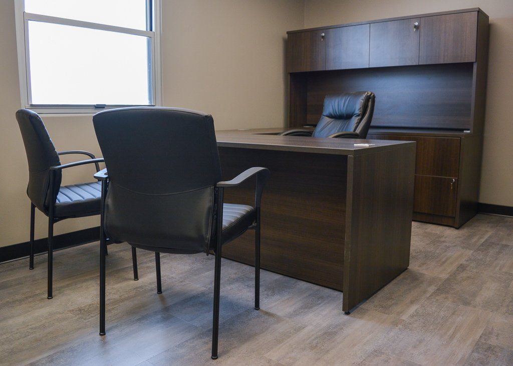 a small office with two chairs in front of a desk