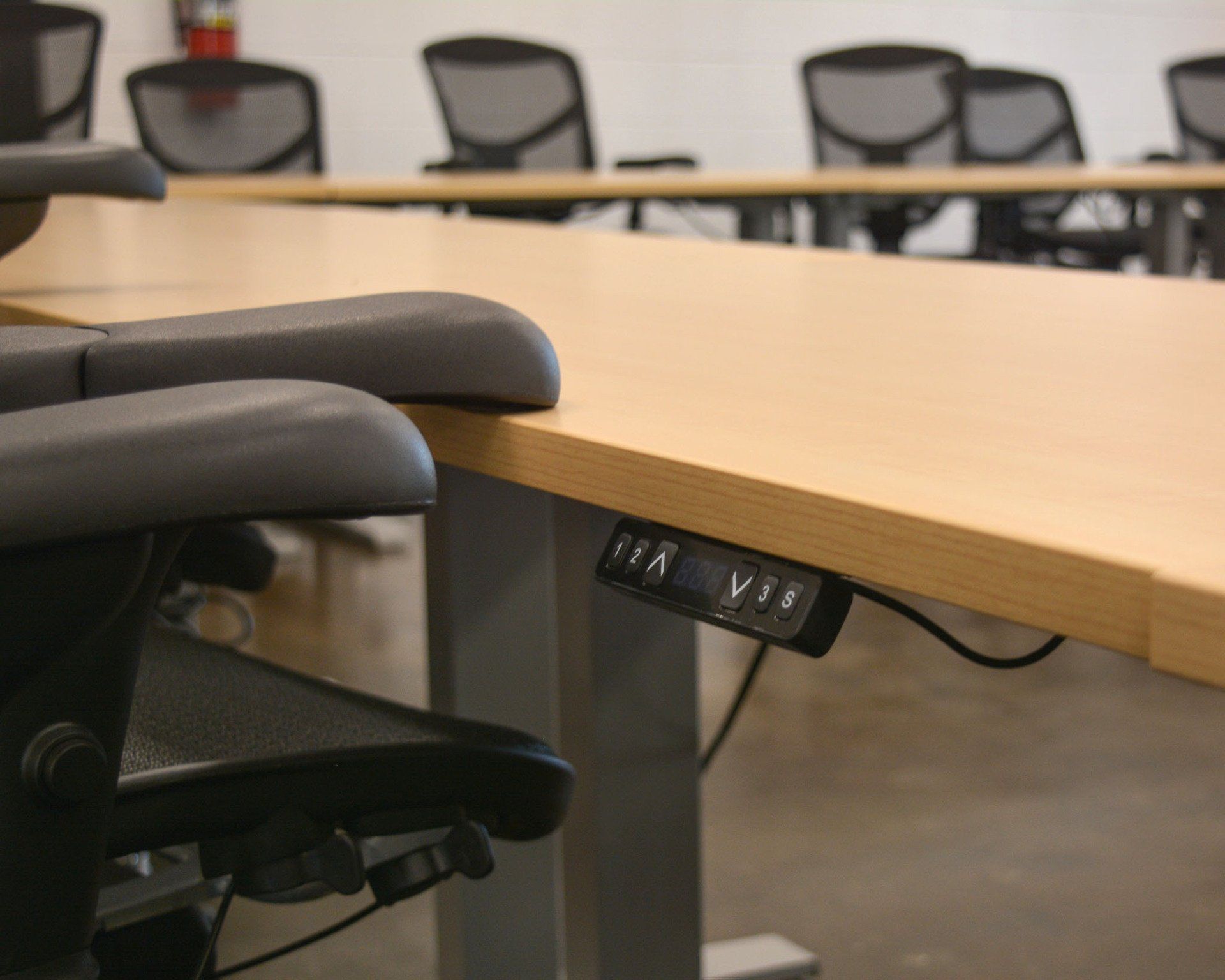 a row of chairs are sitting at a table with a remote control on it