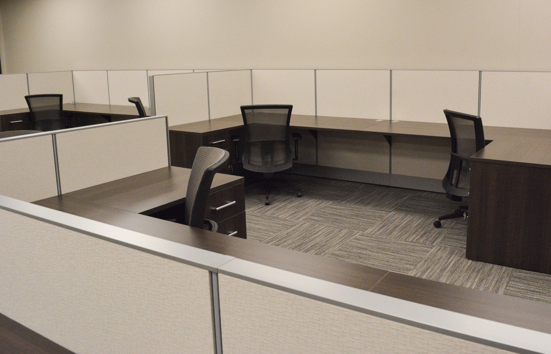 an office cubicle with two desks and two chairs