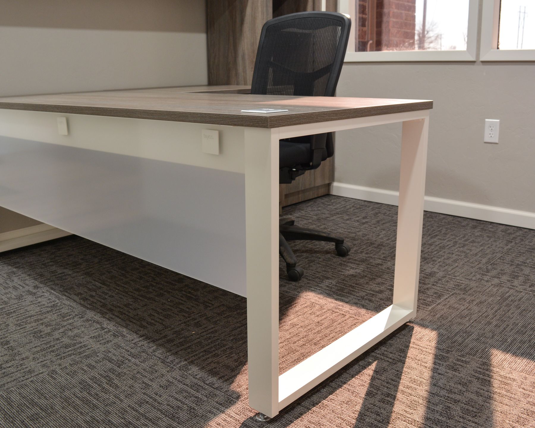 A desk with a chair underneath it in a room.