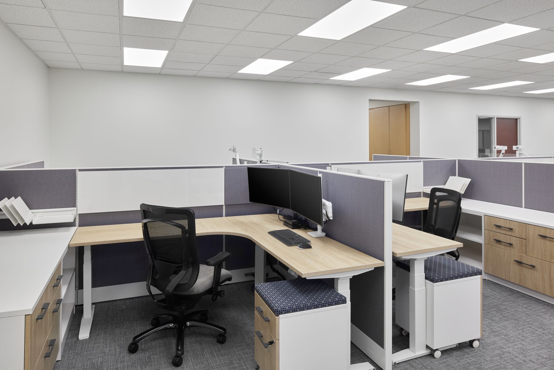 An office with cubicles and a desk with a computer on it.