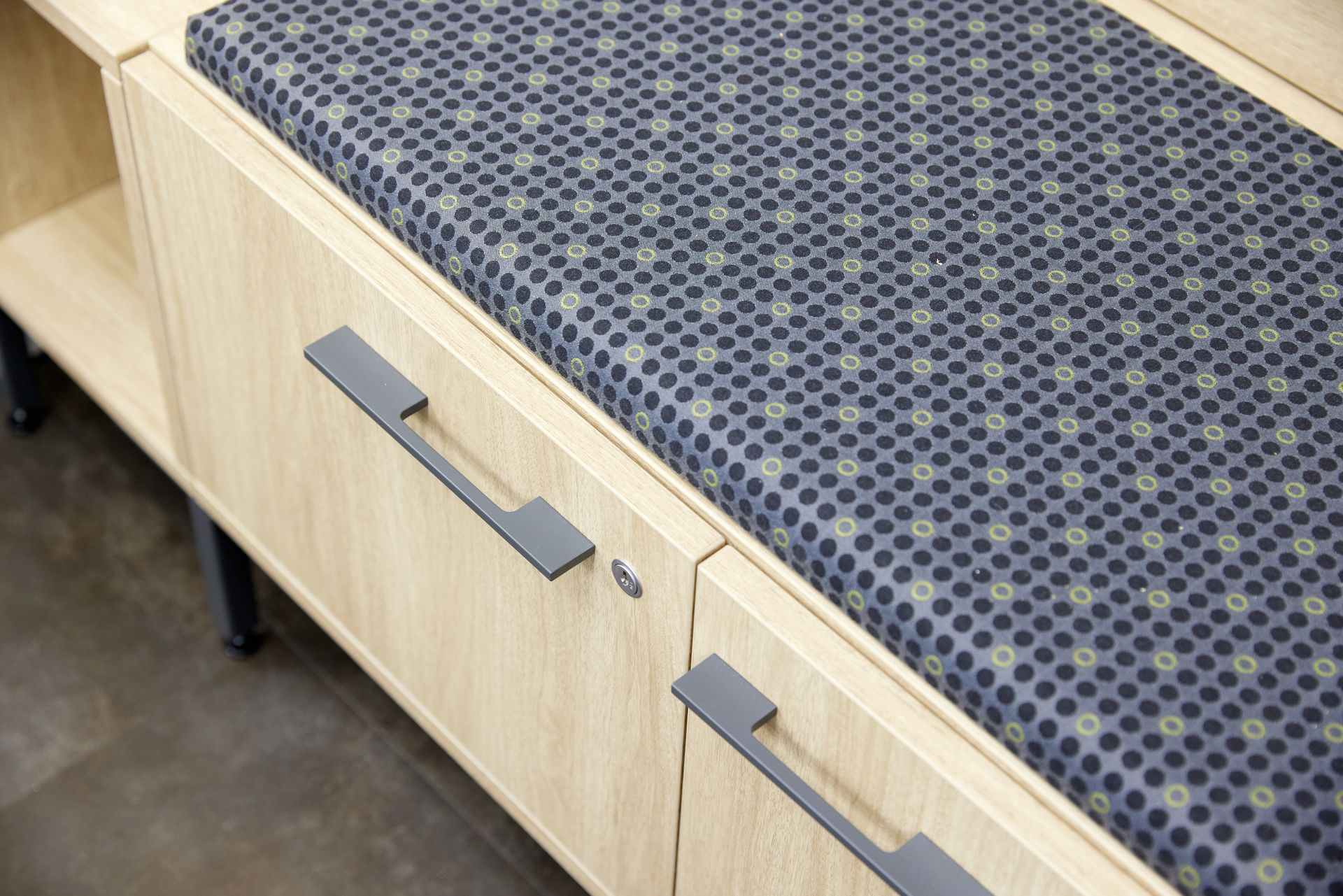 Light woodgrain cabinet with a navy circle patterned cushion on top