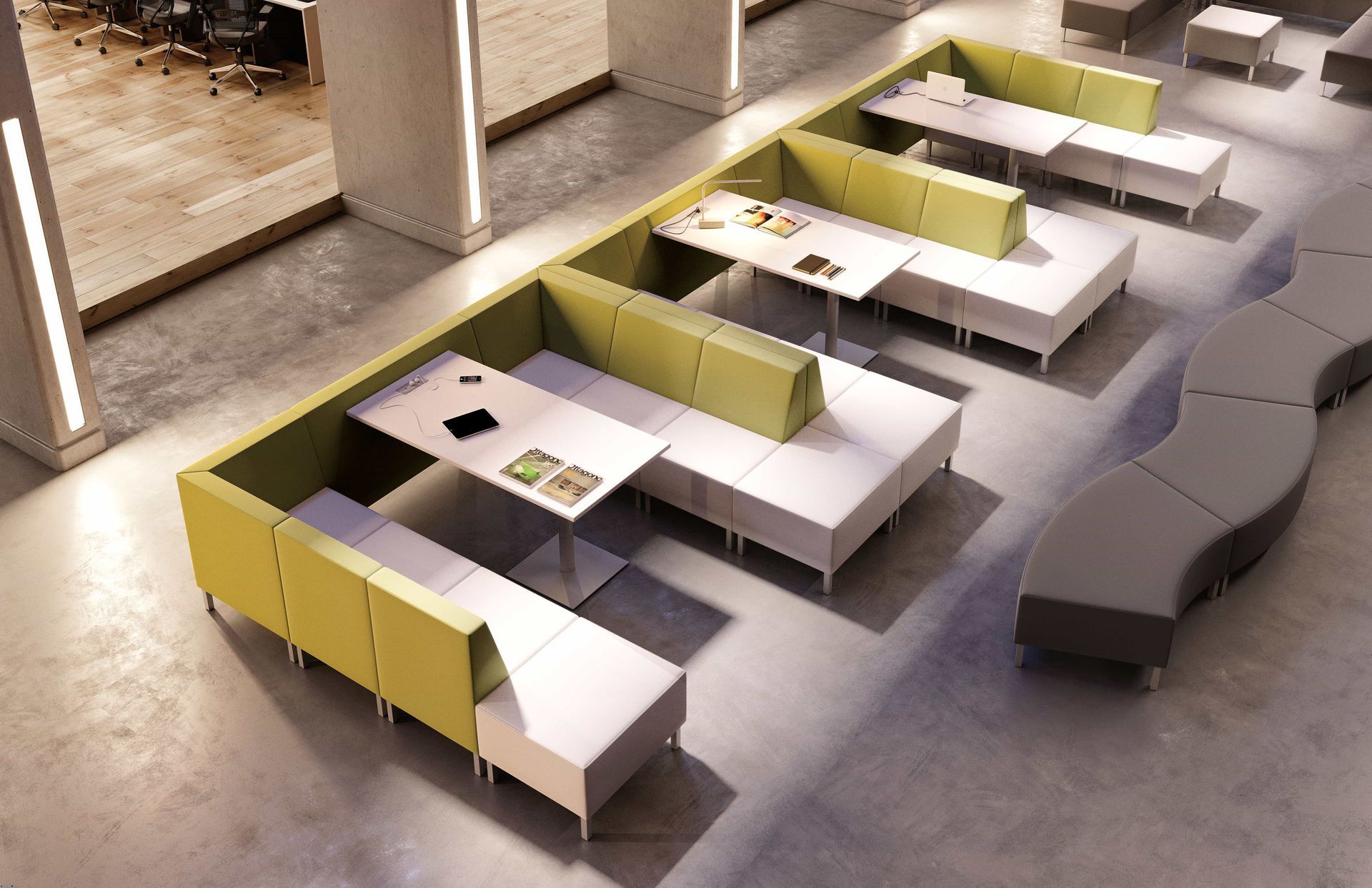 Modern office area with green and white booth seating, tables, and a gray curved backless modular seating.