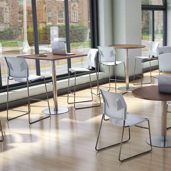 a room with tables and chairs and a laptop on a table