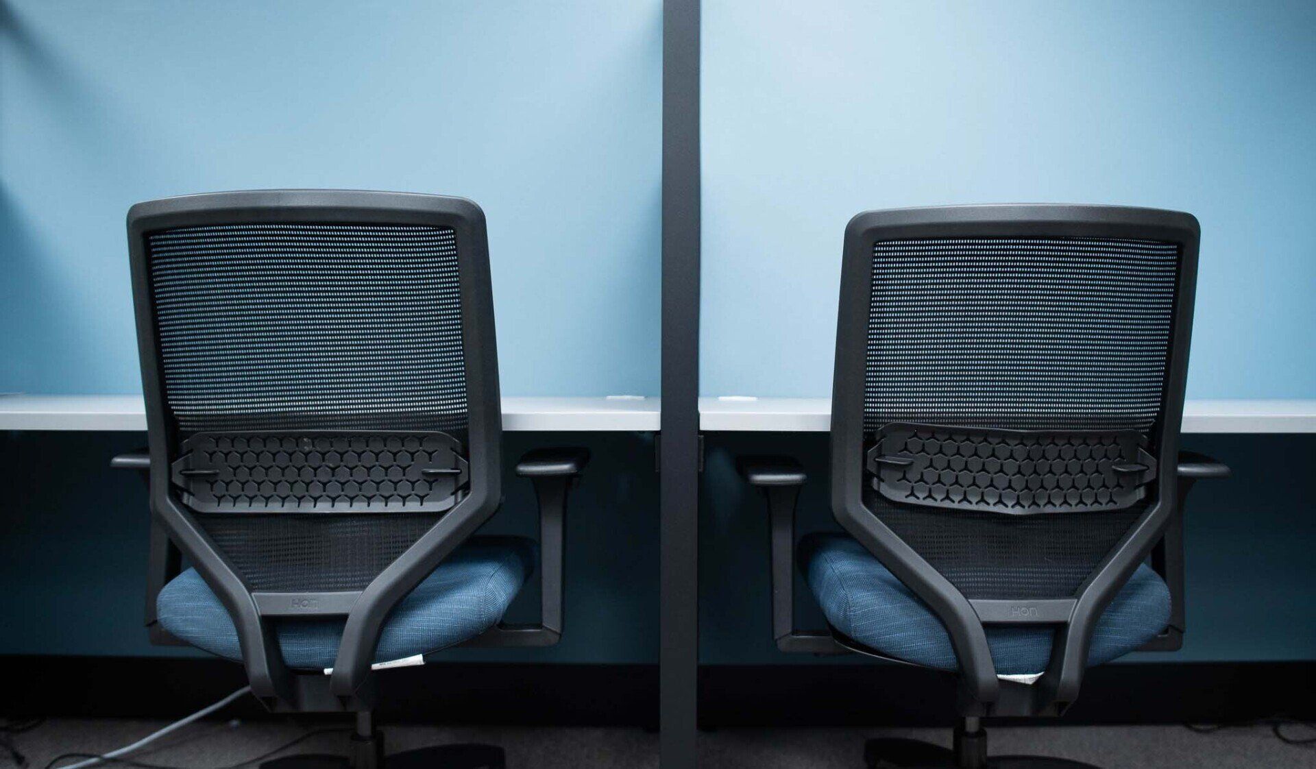 two office chairs are sitting next to each other in a cubicle