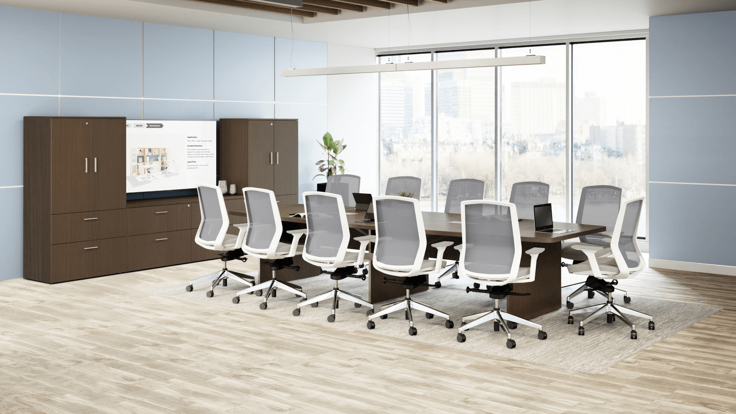 Conference room with long dark table, gray chairs, dark cabinets, and large window.