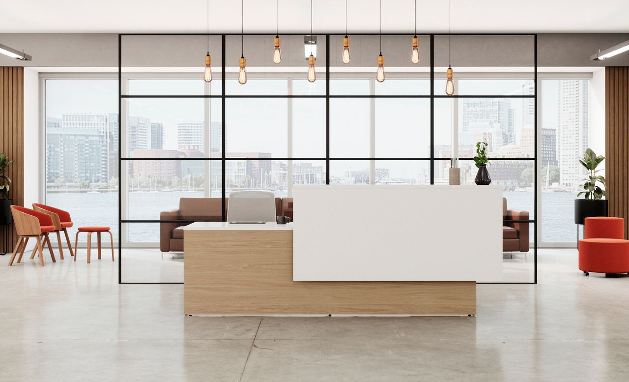 Modern office reception area with a white desk, brown accents, and a city view through large windows.
