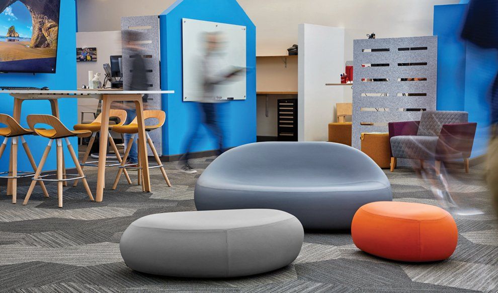 Earthy, rounded sofa and table with blurred people behind