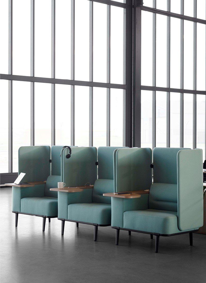 Row of blue chairs with high panels around seat and work tablet desk