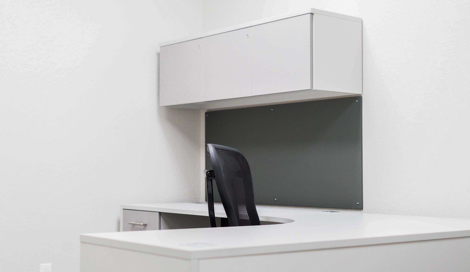 a white desk with a black chair behind it