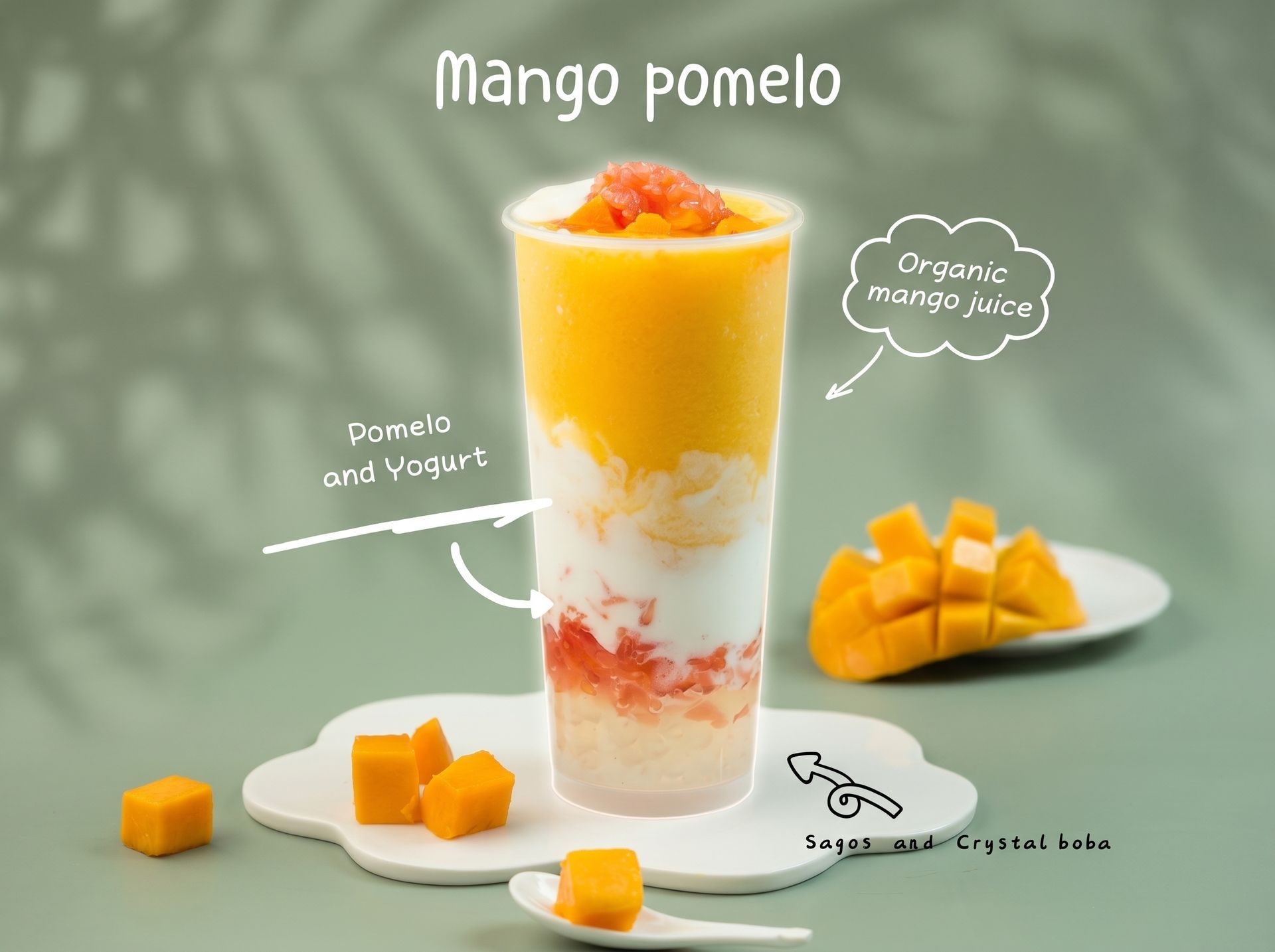 Mango pomelo dessert drink in a tall glass with mango pieces on a light green table