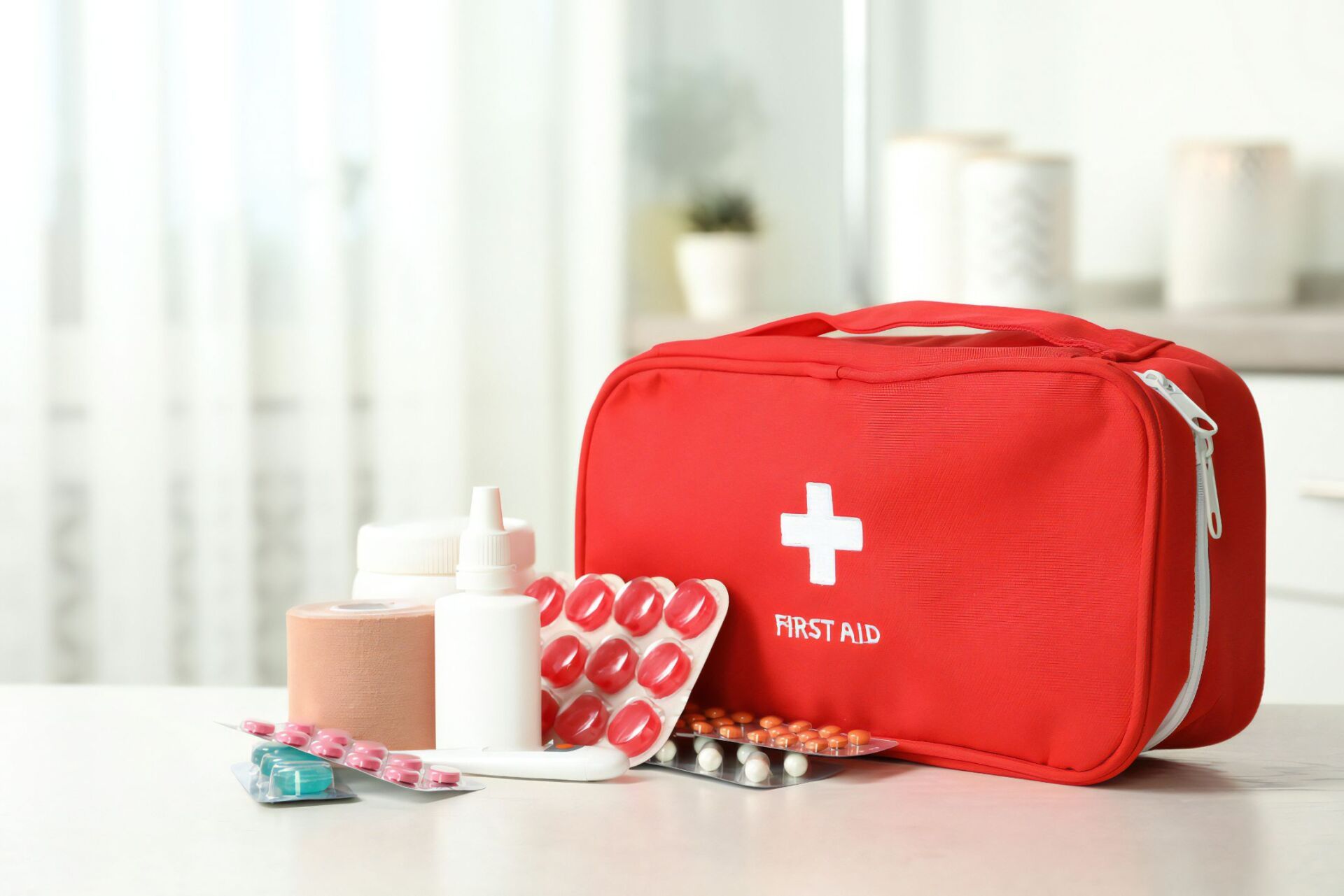 Red First Aid Kit With White Cross and Emergency Supplies on a Table — Revive Training in Alstonville, NSW