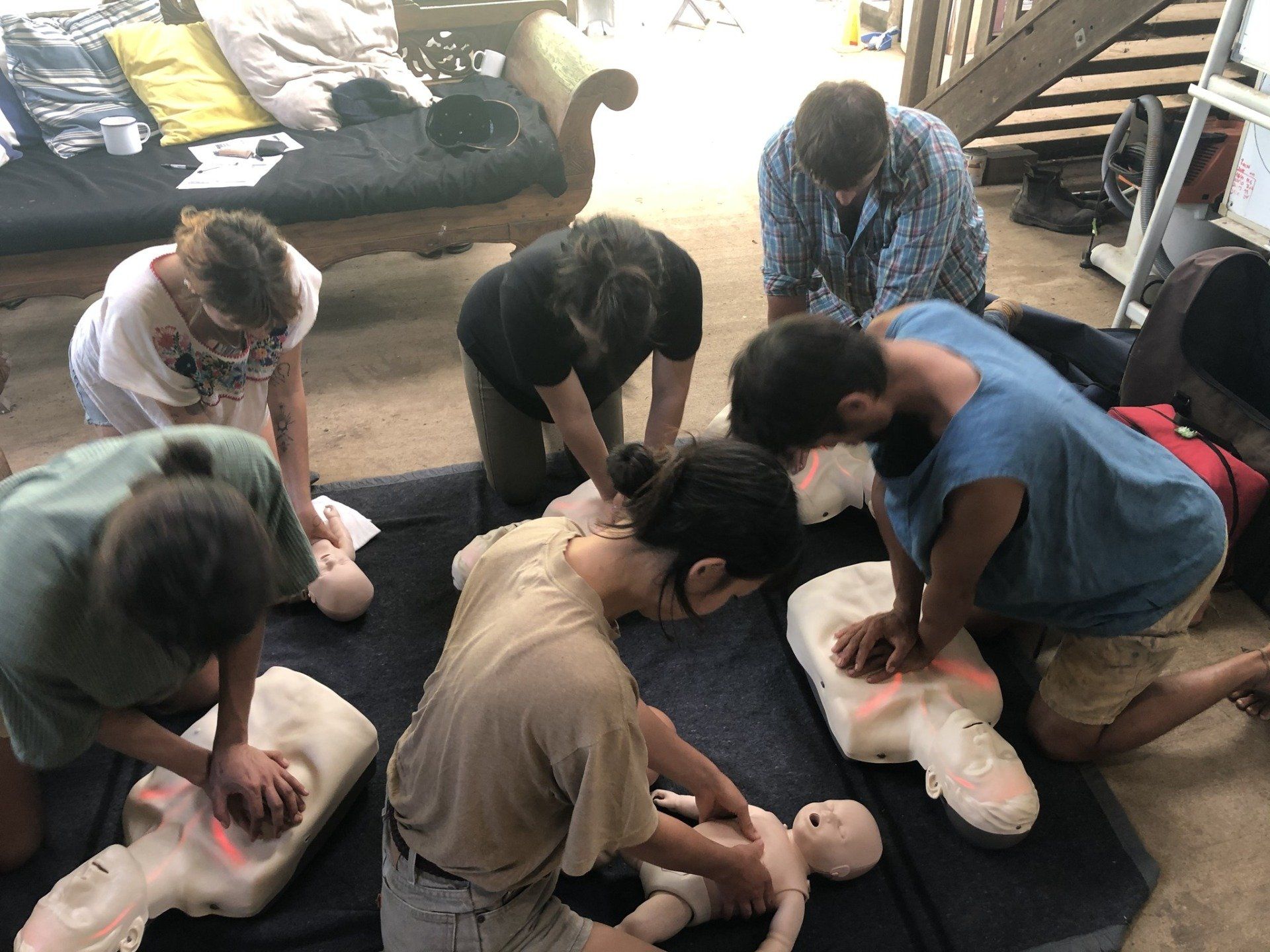 People Kneel Around Infant Mannequins, Practicing CPR and First Aid — Revive Training in Alstonville, NSW