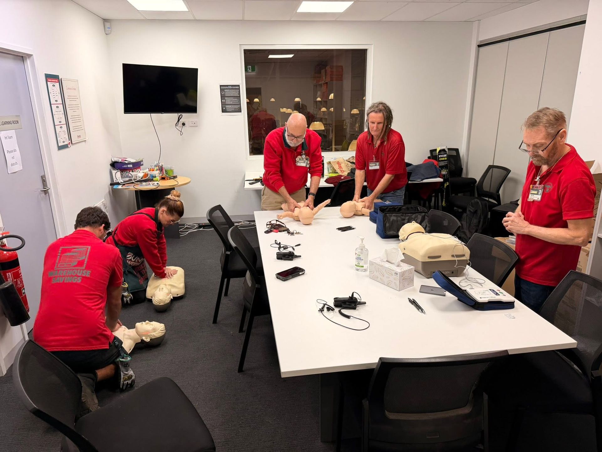 Volunteers in Red Shirts Having a Training Around a Conference Meeting Room — Revive Training in Alstonville, NSW