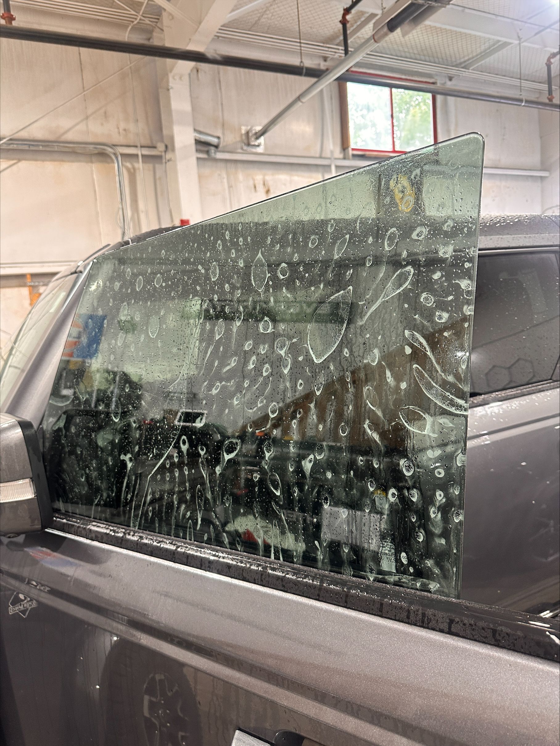 Car door window shattered with shattered glass in a garage or workshop