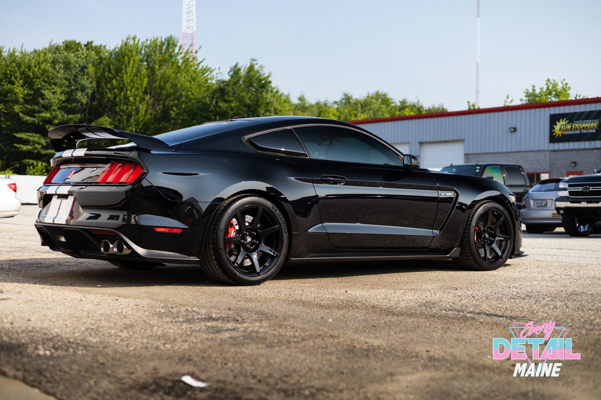 A black ford mustang is parked in a parking lot.