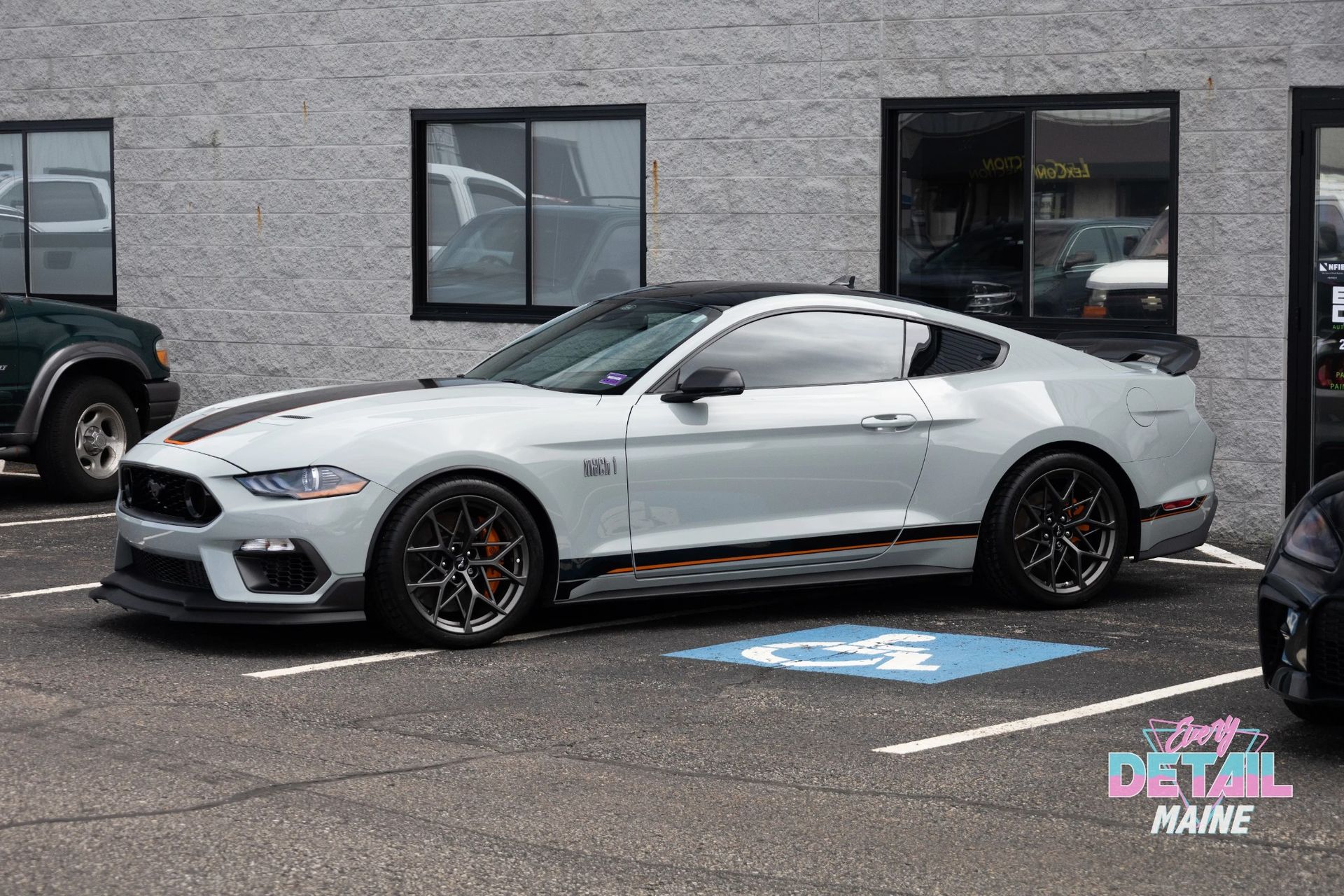 Silver Ford Mustang Mach 1 parked in a lot outside a building