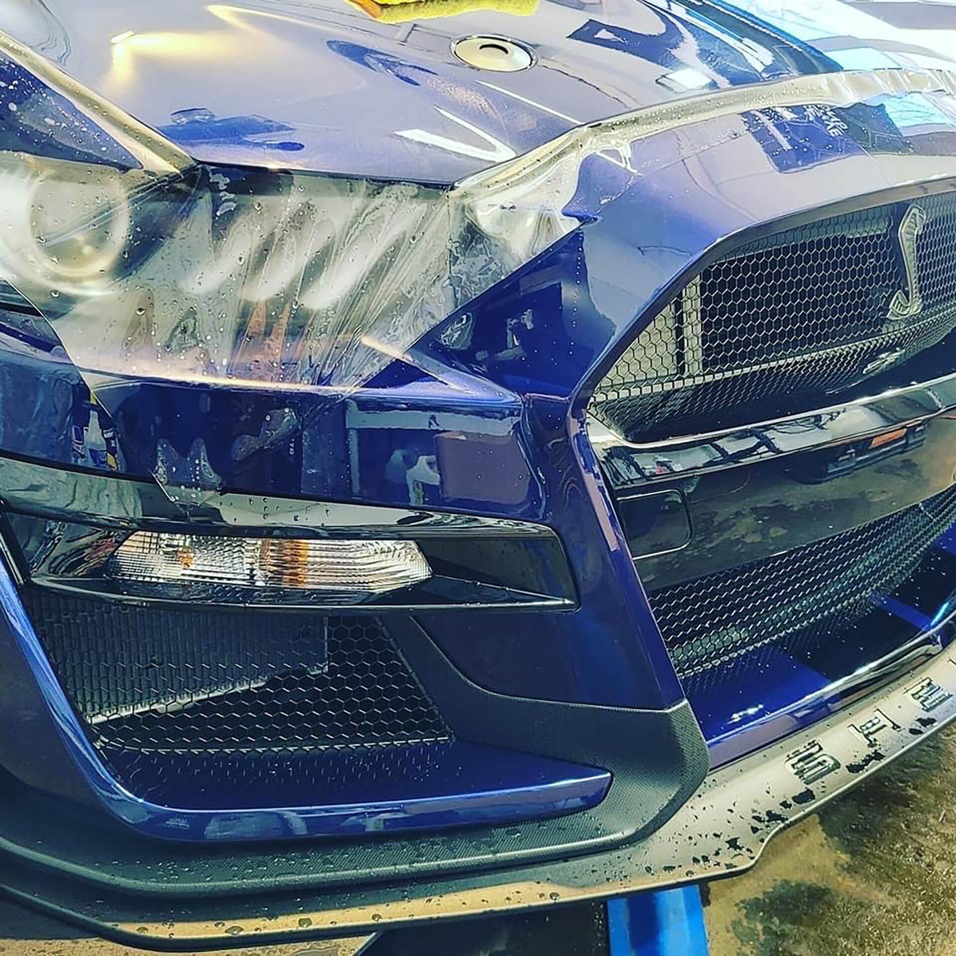 Blue Shelby Mustang with protective film being applied to the front.
