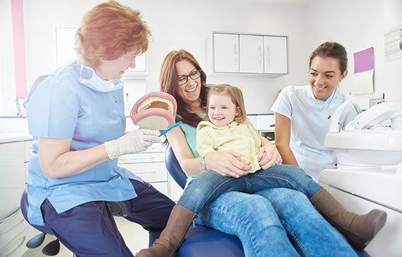 Woman Looking At Her Teeth In A Mirror — Haverhill, MA — Haverhill Dental Associates Inc Woman Looking At Her Teeth In A Mirror — Haverhill, MA — Haverhill Dental Associates Inc