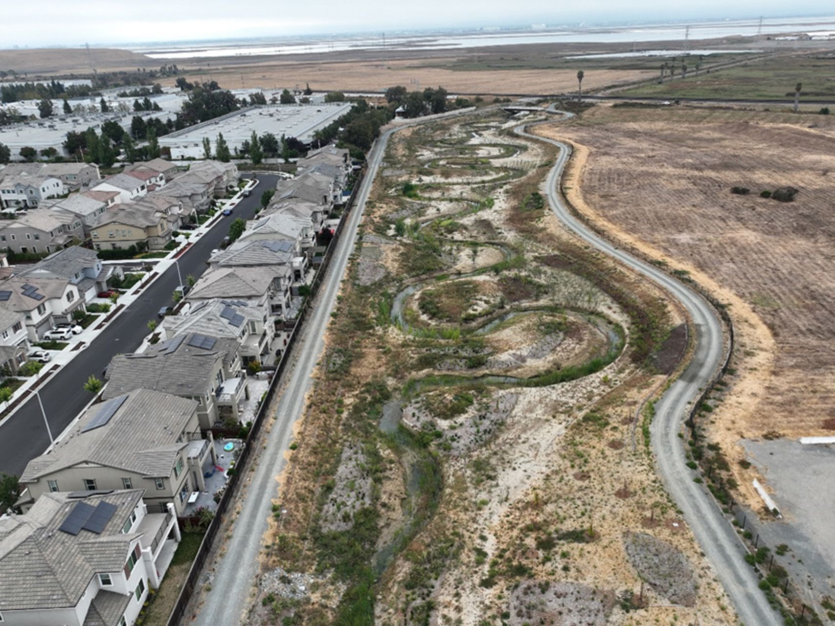 An aerial view of a residential area with a river running through it.