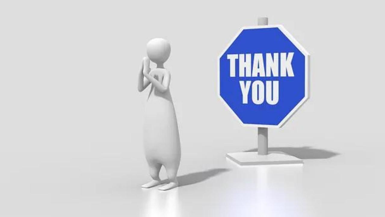 A man is standing next to a blue sign that says thank you