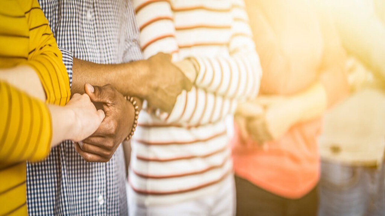 A group of people are holding hands in a circle.